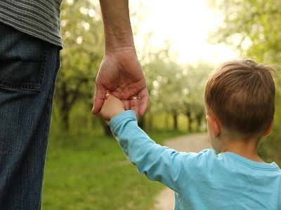 Parent holds white child's hand