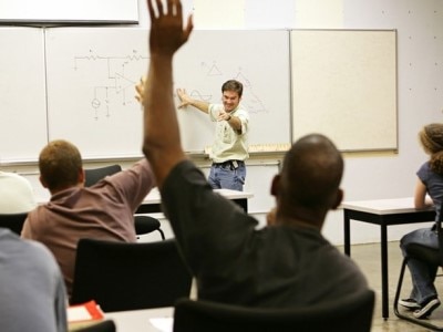 People raising hands in a classroom