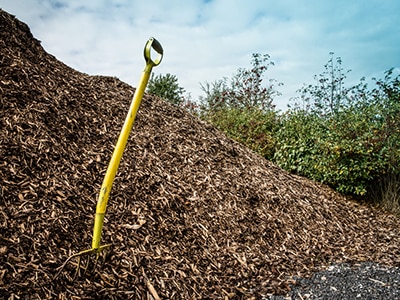A pile of mulch with a shovel